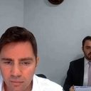 Vorcaro durante depoimento por vídeo à Polícia Federal; ao fundo, o advogado Thiago Machado