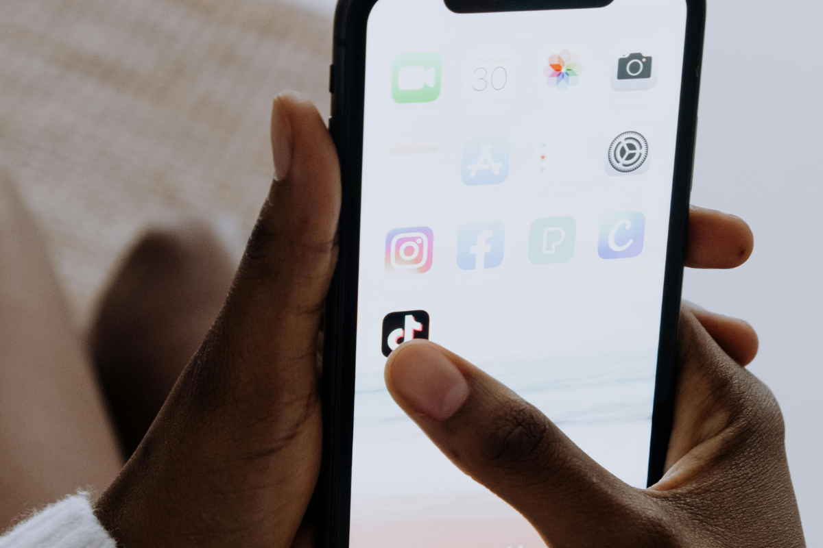 Pessoa abrindo o TikTok no celular