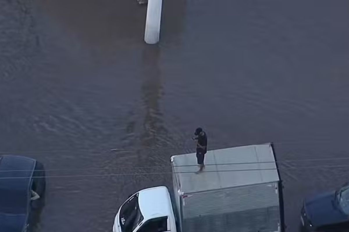 Homem ilhado em alagamento no bairro do Itaim Paulista, extremo Leste de São Paulo. Foto: Reprodução/TV Globo.