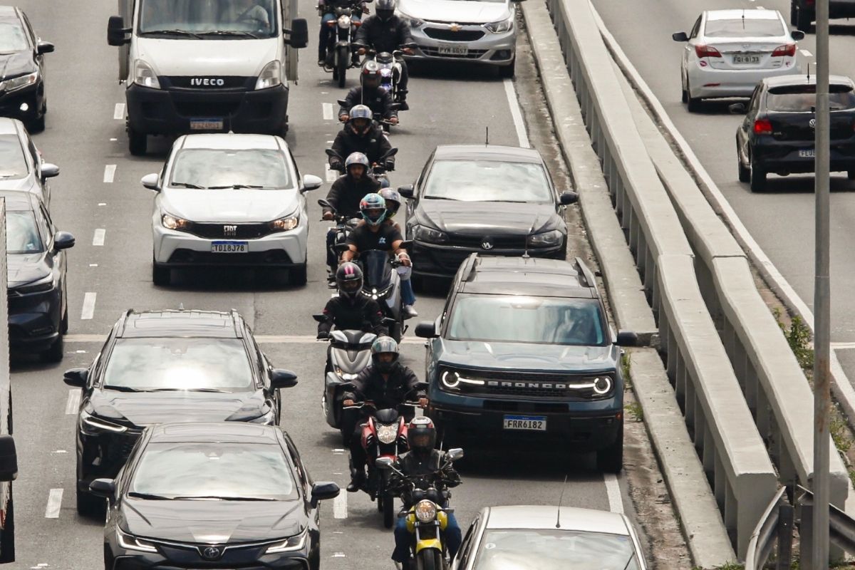 Motos e carros parados em avenida